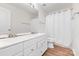 Well-lit bathroom featuring double sinks, white cabinets, and a shower behind a white curtain at 3710 Cheleys Ridge Ln, Charlotte, NC 28270