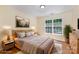 Cozy bedroom with hardwood floors, a wooden bed frame, and a large window at 3710 Cheleys Ridge Ln, Charlotte, NC 28270