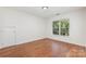 Bright bedroom featuring hardwood floors and a view of lush greenery at 3710 Cheleys Ridge Ln, Charlotte, NC 28270