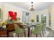Bright dining room featuring modern chandelier, green chairs, glass table, and large windows offering natural light at 3710 Cheleys Ridge Ln, Charlotte, NC 28270