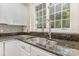 A close up of a sink with stainless steel faucet and dark granite countertops at 3710 Cheleys Ridge Ln, Charlotte, NC 28270