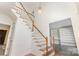 Bright foyer with staircase featuring white railings, wooden banisters, and wainscoting details at 3710 Cheleys Ridge Ln, Charlotte, NC 28270