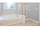 Bathroom featuring a soaking tub, tiled floors, and a glass door shower at 427 Pinnacle Ln, Huntersville, NC 28078