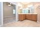 Bathroom with double vanity, tile flooring, large mirror and an open doorway to bedroom at 427 Pinnacle Ln, Huntersville, NC 28078