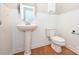 Small powder room features pedestal sink, white wainscotting, wood floors and commode at 427 Pinnacle Ln, Huntersville, NC 28078