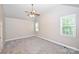 An empty bedroom features plush carpet, neutral walls, ceiling fan and natural light from two windows at 427 Pinnacle Ln, Huntersville, NC 28078