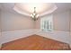Empty dining room with wood flooring, a chandelier, and wainscotting at 427 Pinnacle Ln, Huntersville, NC 28078