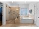 Bathroom features a walk-in shower, soaking tub, and stylish tile work at 440 S Sharon Amity Rd, Charlotte, NC 28211