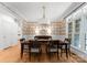 Elegant dining room features hardwood floors, decorative wallpaper, a chandelier, and ample natural light at 440 S Sharon Amity Rd, Charlotte, NC 28211