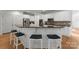 Modern kitchen island with bar seating, white cabinets, dark countertops, and stainless steel appliances at 440 S Sharon Amity Rd, Charlotte, NC 28211