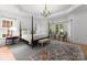 Luxurious bedroom with a four-poster bed, elegant chandelier, and bay windows at 440 S Sharon Amity Rd, Charlotte, NC 28211