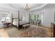 Elegantly designed primary bedroom with a four-poster bed, chandelier, and bay windows at 440 S Sharon Amity Rd, Charlotte, NC 28211