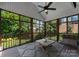 Cozy screened-in porch with wood floors, a ceiling fan and plenty of natural light at 440 S Sharon Amity Rd, Charlotte, NC 28211