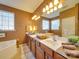 Bathroom with dual sink vanity, soaking tub, and a window offering natural light at 5076 Timber Falls Dr, Indian Land, SC 29707