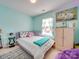 Stylish bedroom with bright teal walls, window with curtains, and decor at 5076 Timber Falls Dr, Indian Land, SC 29707