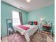 Cozy bedroom featuring bright teal walls, window, and stylish decor at 5076 Timber Falls Dr, Indian Land, SC 29707