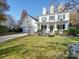 Charming two-story home with a well-manicured lawn, seating, and a welcoming front porch at 5076 Timber Falls Dr, Indian Land, SC 29707