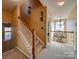 Bright hallway featuring a staircase with carpeted steps and a chandelier lit alcove at 5076 Timber Falls Dr, Indian Land, SC 29707