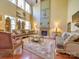 Elegant living room featuring high ceilings, large windows, a fireplace, and luxury furniture at 5076 Timber Falls Dr, Indian Land, SC 29707