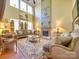 Elegant living room featuring high ceilings, large windows, a fireplace, and luxury furniture at 5076 Timber Falls Dr, Indian Land, SC 29707