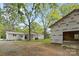 A view of the home's backyard, featuring an unfinished garage, an attached carport, and a grassy lawn at 528 W Park Dr, Monroe, NC 28112