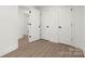 Hallway with white doors, black hardware, and wood-look flooring creating a sleek design at 528 W Park Dr, Monroe, NC 28112