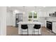 Modern kitchen features white cabinets, stainless steel appliances, a center island with seating, and stylish pendant lighting at 528 W Park Dr, Monroe, NC 28112
