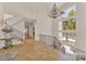 Bright, open foyer with hardwood floors, staircase, grand chandelier, and floor-to-ceiling windows at 611 Wisteria Vines Trl, Fort Mill, SC 29708