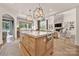 Open kitchen with large island, bar seating, stone fireplace in the connected living area, and hardwood floors at 611 Wisteria Vines Trl, Fort Mill, SC 29708