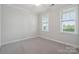 Neutral bedroom showcasing carpet, crown molding, and windows providing ample light at 6220 Raven Rock Dr, Denver, NC 28037