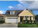 Charming yellow house featuring a well-manicured lawn, inviting front porch, and a convenient attached garage at 6220 Raven Rock Dr, Denver, NC 28037