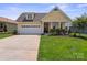Charming yellow home featuring a two-car garage and professionally landscaped front yard at 6220 Raven Rock Dr, Denver, NC 28037
