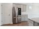 Modern kitchen features stainless steel refrigerator, subway tile backsplash, and gray cabinets at 6220 Raven Rock Dr, Denver, NC 28037