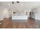 Open concept kitchen features gray cabinets, granite counters, stainless appliances, and hardwood floors at 6220 Raven Rock Dr, Denver, NC 28037