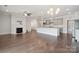 Expansive living room featuring hardwood floors, modern fireplace, stylish lighting, and an open concept kitchen at 6220 Raven Rock Dr, Denver, NC 28037