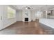 Inviting living room featuring hardwood floors, a cozy fireplace, and an open layout to the kitchen at 6220 Raven Rock Dr, Denver, NC 28037