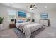 Serene bedroom with a large bed, stylish decor, and ample natural light from the two windows at 6220 Raven Rock Dr, Denver, NC 28037