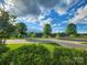 Residential street view showcases mature trees and well-maintained lawns under a blue sky at 6220 Raven Rock Dr, Denver, NC 28037