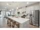 A modern kitchen is shown with stainless steel appliances, white cabinets and a large island with seating for four at 6242 Ashton Park Dr, Denver, NC 28037