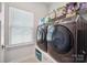Laundry room equipped with modern front-load washer and dryer units and ample storage shelving at 6242 Ashton Park Dr, Denver, NC 28037