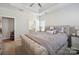 The main bedroom features a tufted headboard, a tray ceiling with fan, and calming neutral tones at 6242 Ashton Park Dr, Denver, NC 28037