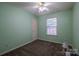 Cozy bedroom with mint-green walls, carpet, window, and ceiling fan at 6808 Squirrels Foot Ct, Charlotte, NC 28217