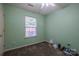 A simple green-painted bedroom featuring a window, carpet, and ceiling fan at 6808 Squirrels Foot Ct, Charlotte, NC 28217