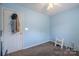 Light-filled blue bedroom with neutral carpet, showing a door and ceiling fan at 6808 Squirrels Foot Ct, Charlotte, NC 28217