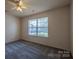 Well-lit carpeted bedroom featuring a window offering views of the neighborhood at 6808 Squirrels Foot Ct, Charlotte, NC 28217