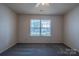 Carpeted bedroom featuring a bright window providing neighborhood views at 6808 Squirrels Foot Ct, Charlotte, NC 28217