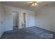 Bedroom with carpet and ceiling fan, alongside doors leading to closet and bathroom at 6808 Squirrels Foot Ct, Charlotte, NC 28217