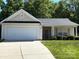 Front view of a single-story home featuring a garage, inviting entrance, and well-kept lawn at 6808 Squirrels Foot Ct, Charlotte, NC 28217