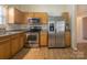 Kitchen area featuring stainless steel appliances, light wood cabinets, and granite countertops at 6808 Squirrels Foot Ct, Charlotte, NC 28217