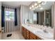 A bathroom with double sinks, bright lighting, and striped wallpaper at 727 Skinner Rd, Shelby, NC 28152